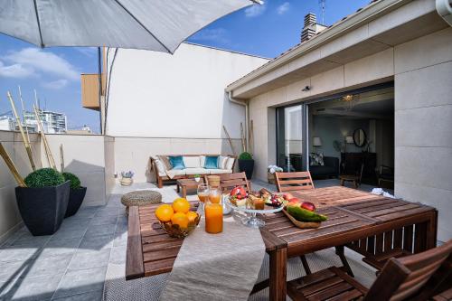 een tafel met fruit op een patio met een parasol bij HQ Rooms Apartments San Vicente in Valencia