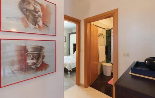 a hallway with two paintings of a man on a wall at Apartments Jelavić in Sutomišćica