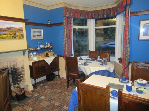 a blue room with two tables and a window at Brookfield B&B Guest House in Keswick