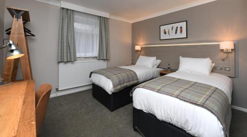 um quarto de hotel com duas camas e uma janela em Green Lodge, Wirral by Marston's Inns em Hoylake