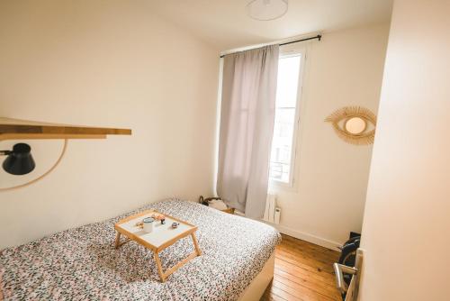 ヴィルジュイフにあるMy Cosy Home Paris Villejuifの小さなベッドルーム(ベッド1台、テーブル付)