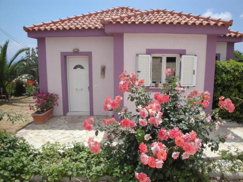 a small house with pink flowers in front of it at Fiora Villas in Trapezaki