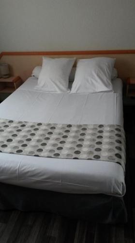 a large bed with white sheets and pillows at Maison Jean le Bon in Dax