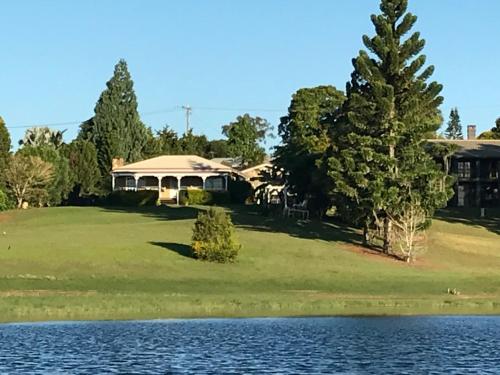 a house on a golf course next to a lake at Lakefront holiday villa in Yungaburra