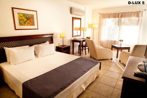 ビテツにあるSah Hotelのベッドとリビングルームが備わるホテルルームです。