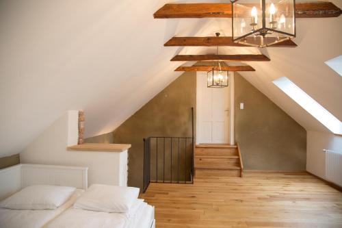 a attic bedroom with a bed and a staircase at Exklusive Ferienwohnung Bad Fischau in Bad Fischau