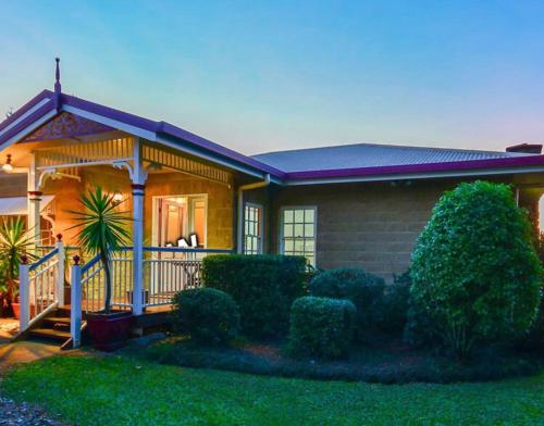a house with bushes in front of it at Lakefront holiday villa in Yungaburra