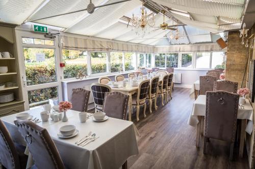 a dining room with tables and chairs and windows at Cricket Field House in Salisbury