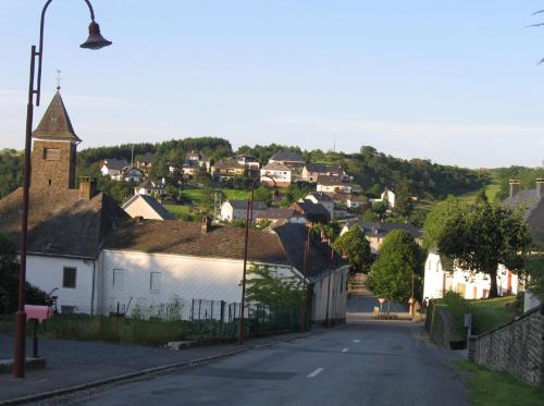 a small village with a church on a hill at Apartment " PENSCH " in Wilwerwiltz