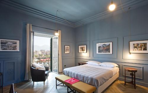 ein Schlafzimmer mit einem Bett, einem Stuhl und einem Fenster in der Unterkunft Stylish apartment in the center of Naples by Wonderful Italy in Neapel