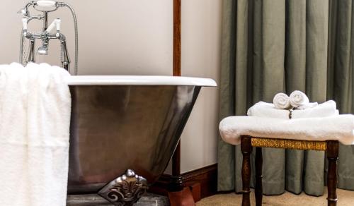 a bathroom with a bath tub and a towel at Shieldaig Lodge Hotel in Gairloch