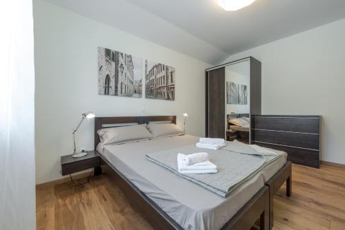 a bedroom with a bed with two towels on it at Villa Nespola Penthouse in Cavtat