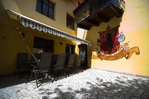 a patio with chairs and a table on the side of a building at Curtea Brasoveana in Braşov