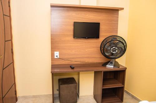 a room with a desk with a fan and a tv at Hotel Camocim in Camocim