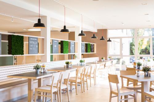 a row of tables and chairs in a restaurant at JUFA Hotel Graz City in Graz