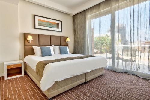 a bedroom with a large bed and a large window at The George, Urban Boutique Hotel in St. Julianʼs