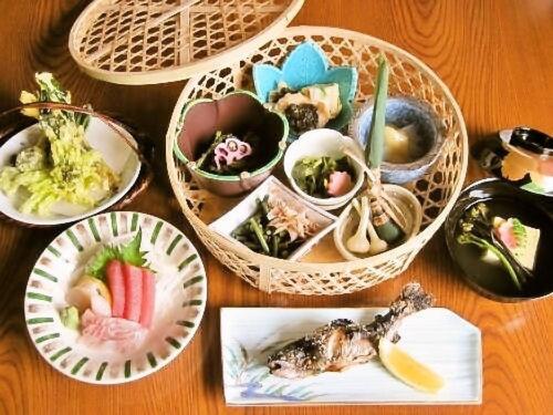 una mesa cubierta con cestas llenas de platos de comida en Yamanokami Onsen, en Nagano