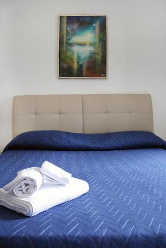 a towel on a bed with a painting on the wall at Parco d'Arte AltArt in Rende
