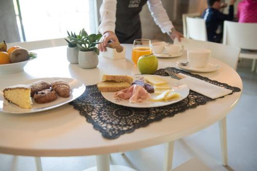 a table with plates of breakfast food on it at Ramo d'Aria Etna Boutique Hotel in Giarre