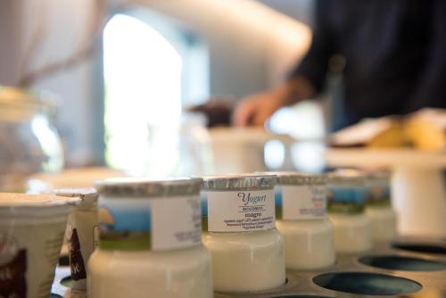 a group of containers of milk on a counter at Ramo d'Aria Etna Boutique Hotel in Giarre