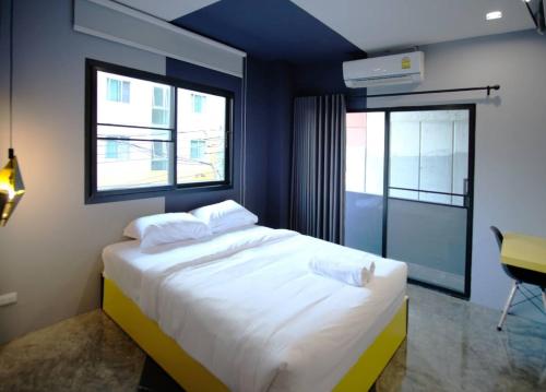 sypialnia z dużym białym łóżkiem z 2 poduszkami w obiekcie Ratch66 Huai Khwang MRT w mieście Bangkok