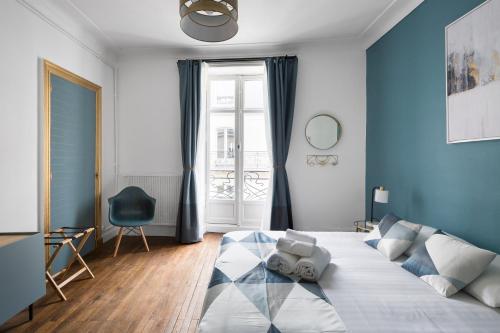 - une chambre avec un grand lit aux murs bleus dans l'établissement Le Prestige by Cocoonr, à Nantes