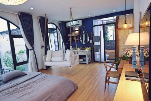 a bedroom with a bed and a desk and chairs at The Gallery House in Hanoi