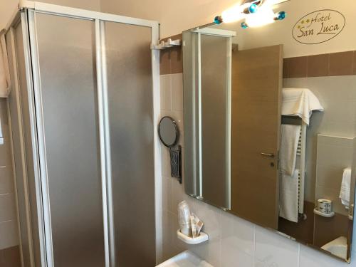 W łazience znajduje się prysznic i lustro. w obiekcie Hotel San Luca w mieście Rossano