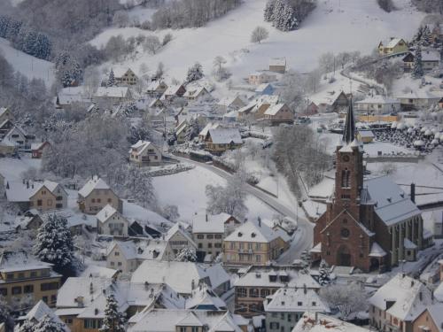 a small town covered in snow with a church at Gite en pleine verdure au coeur du village in Lapoutroie