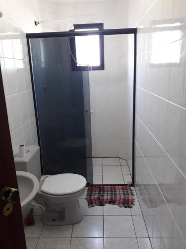 een badkamer met een toilet en een douchecabine bij Apartamento inteiro in Praia Grande