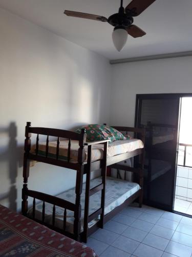 ein Schlafzimmer mit einem Etagenbett und einem Deckenventilator in der Unterkunft Apartamento inteiro in Praia Grande