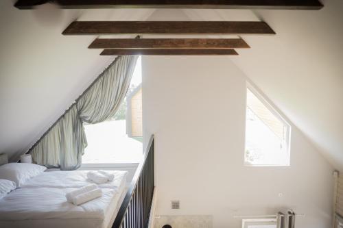 a attic bedroom with a bed and a window at Jaśminowy Sad in Mikołajki