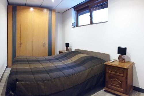 ein Schlafzimmer mit einem großen Bett und einem Holzschrank in der Unterkunft Gîte du Burkendal in Aumetz