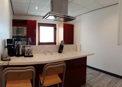 - une cuisine avec un comptoir et des chaises dans la chambre dans l'établissement Gîte du Burkendal, à Aumetz