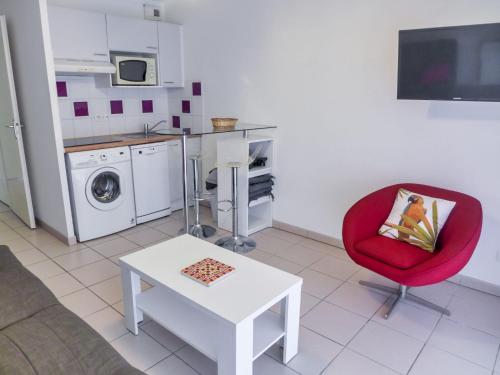 un salon avec une chaise rouge et une table dans l'établissement Apartment l'Allée des Dunes-9 by Interhome, à Ondres