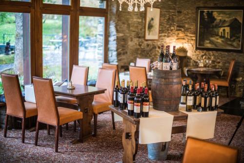 a wine tasting room with wine bottles on tables and chairs at Domaine du Moulin d'Asselborn in Asselborn