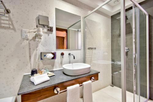 uma casa de banho com um lavatório e um chuveiro em The George, Urban Boutique Hotel em St. Julian's