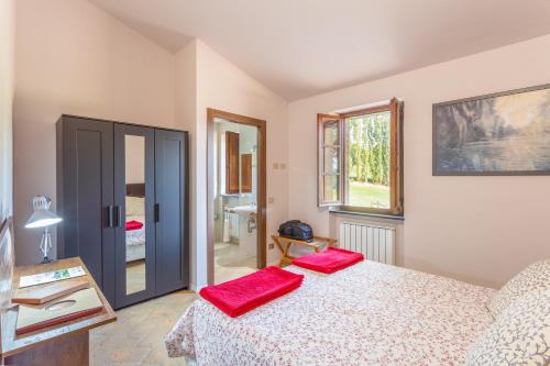 a bedroom with a bed with red pillows on it at GH Borgo Pulciano Agriturismo in Montone