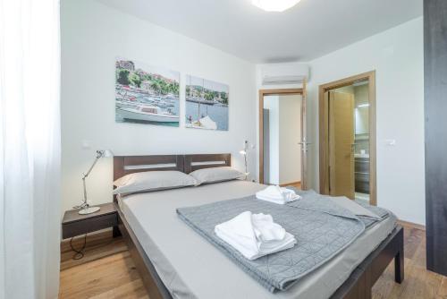 ein Schlafzimmer mit einem Bett mit weißen Handtüchern darauf in der Unterkunft Villa Nespola in Cavtat