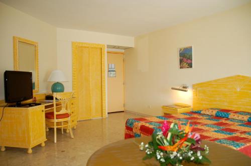 ein Hotelzimmer mit einem Bett und einem Tisch in der Unterkunft Hotel La Galleria in Le Lamentin