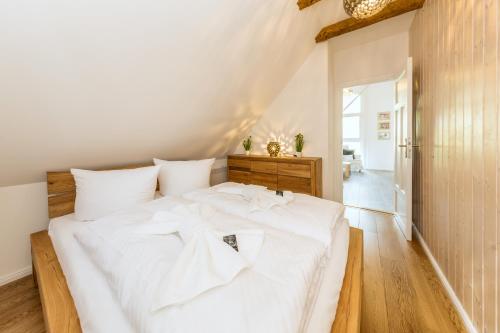 a bedroom with a large white bed with white sheets at SATAMA Sauna Resort & SPA in Wendisch Rietz