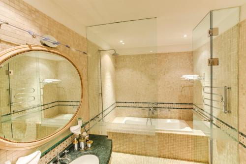 a bathroom with a tub and a sink and a mirror at The Pucic Palace in Dubrovnik