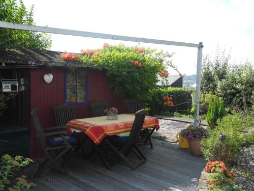 a table and chairs sitting on a wooden deck at Ferienwohnung Schneider in Ormesheim