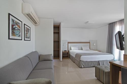 a hotel room with a couch and a bed at Space Residence in Manaus