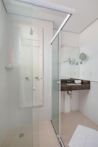 a bathroom with a glass shower and a sink at Space Residence in Manaus
