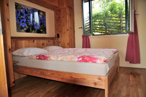 1 dormitorio con 1 cama en una habitación con ventana en Sulamith Ferienhaus mit Garten, en Sankt Kathrein am Offenegg