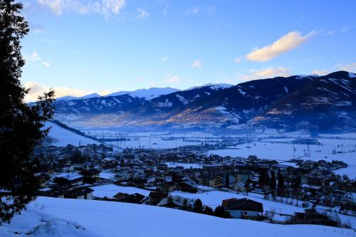 a town covered in snow with mountains in the background at Panorama Hotel Guggenbichl - inkl Sommerkarte, einmaliger Eintritt ins Tauern Spa & bester Ausblick über Kaprun in Kaprun