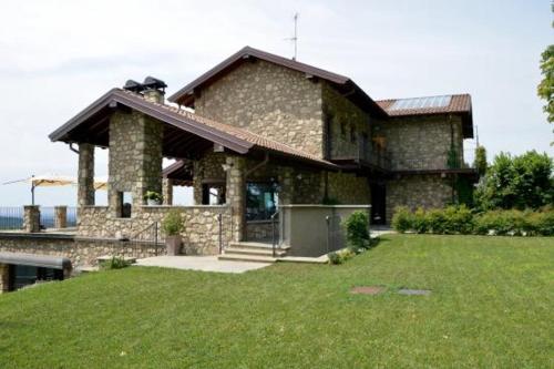 una gran casa de piedra con césped delante en AGRITURISMO SAN GENESIO en Rovagnate