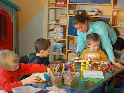 a group of children sitting around a table playing with toys at Aquamaris Strandresidenz Rügen in Juliusruh