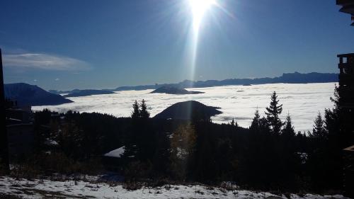 a view of a snow covered mountain with the sun at Chamrousse 1750 - Le Taillefer - Appartement classé 3 étoiles in Chamrousse
